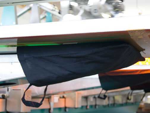 Hier ist zu sehen, wie eine schwarze Baumwolltasche auf eine Druckpalette aufgezogen ist